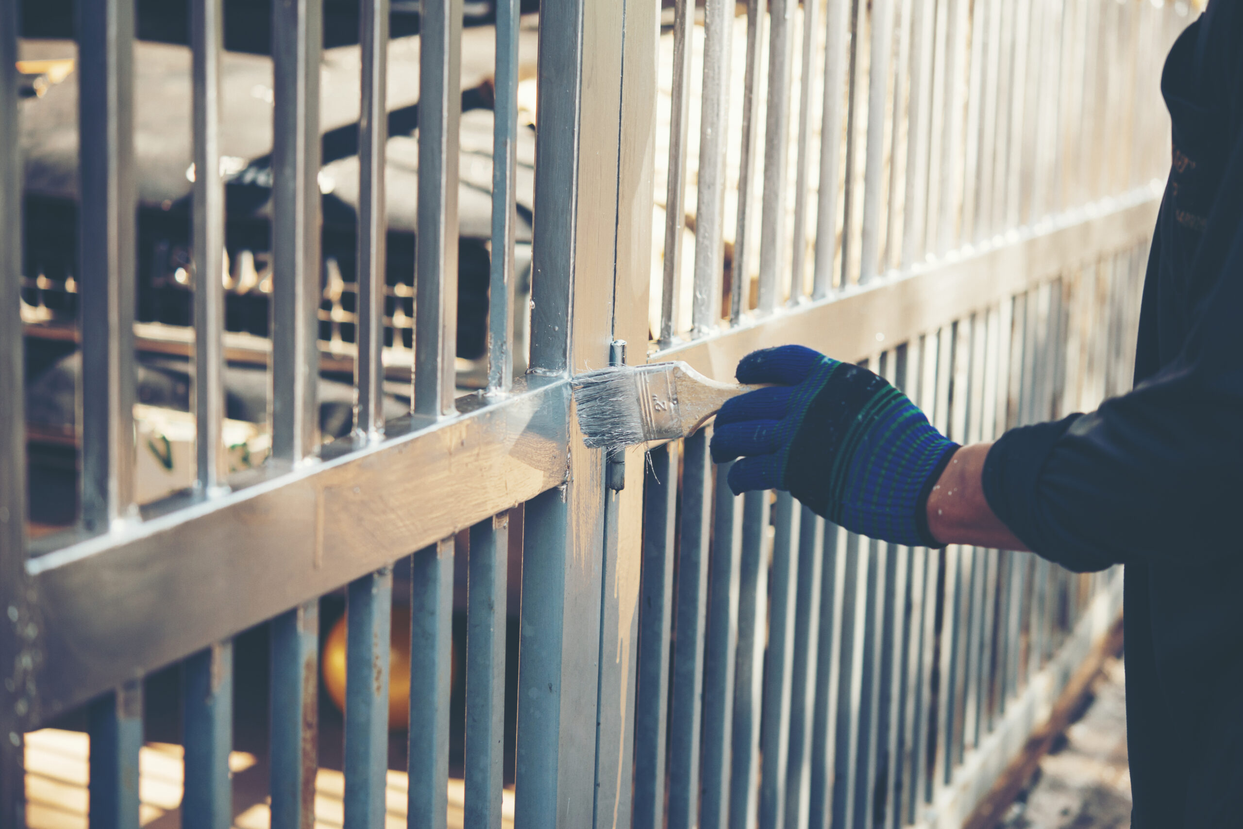 Construction worker painting fence at home, closeup